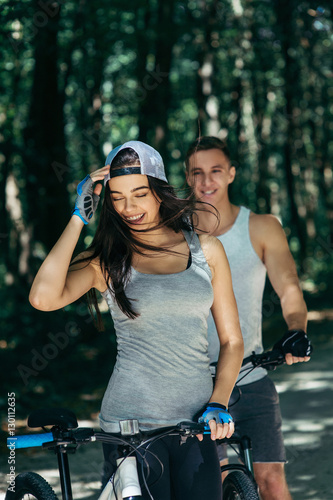 Young Couple Riding Bike In Park