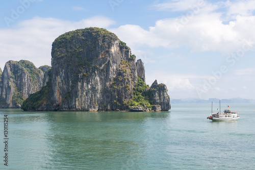A small boat in Halong Bay next to a rock © kyrien