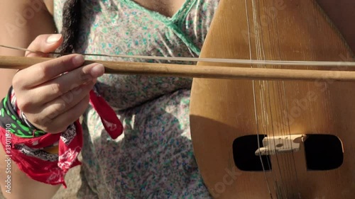 old european string instrument: young street artist woman playing a old string  photo