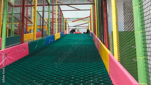 the little girl on the tubing rolls with slides in the play area