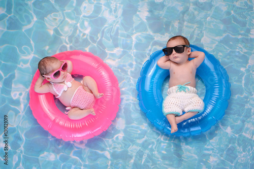 Vászonkép Baby Twin Boy and Girl Floating on Swim Rings