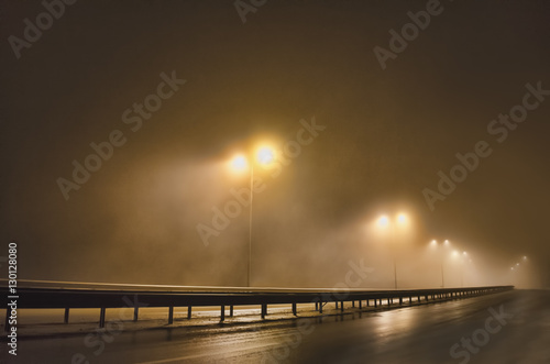 Street lights, foggy night, lamp post lanterns, deserted road in mist fog, wet asphalt and tram