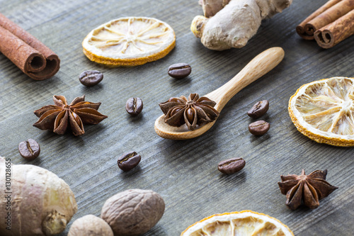 star anise, dried lemon, cinnamon, ginger and coffee beans with wooden spoon on wooden table