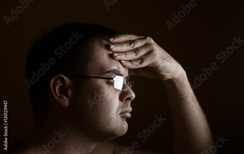 Man with tired eyes after long work holding his eyeglasses