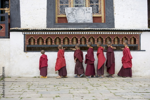 Buddhist monks turning prayer wheels, Karchu Dratsang Monastery, Jankar, Bumthang, Bhutan