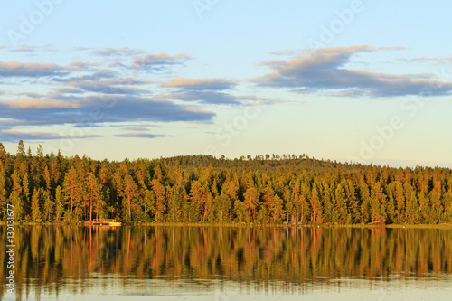 Lake at sunset among dense forest