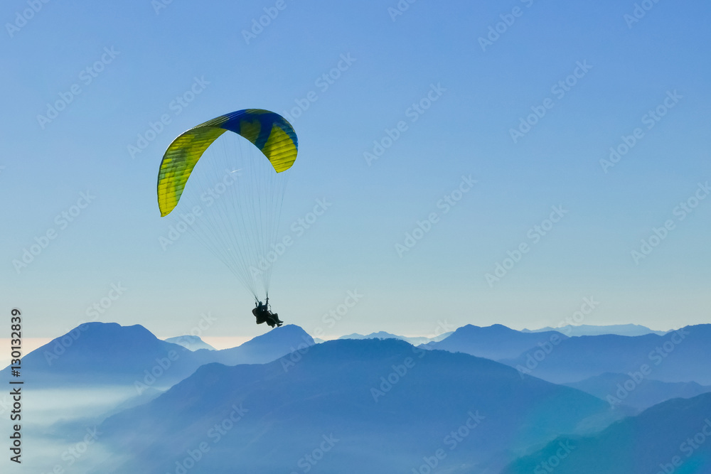 Paragliding tandem flying over the mountains. Freedom concept Paragliding tandem flying over the mountains. Freedom concept