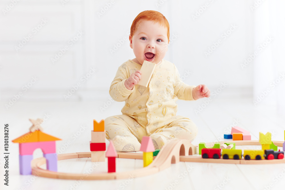 cute ginger baby playing with toy railway road at home cute ginger baby playing with toy railway road at home
