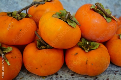 Pile of ripe orange persimmon fruit photo
