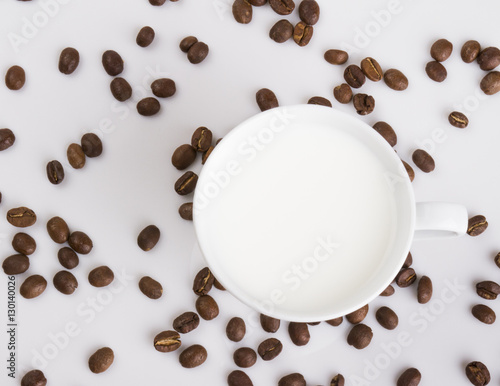 Cup of coffee with coffee grains on a light background