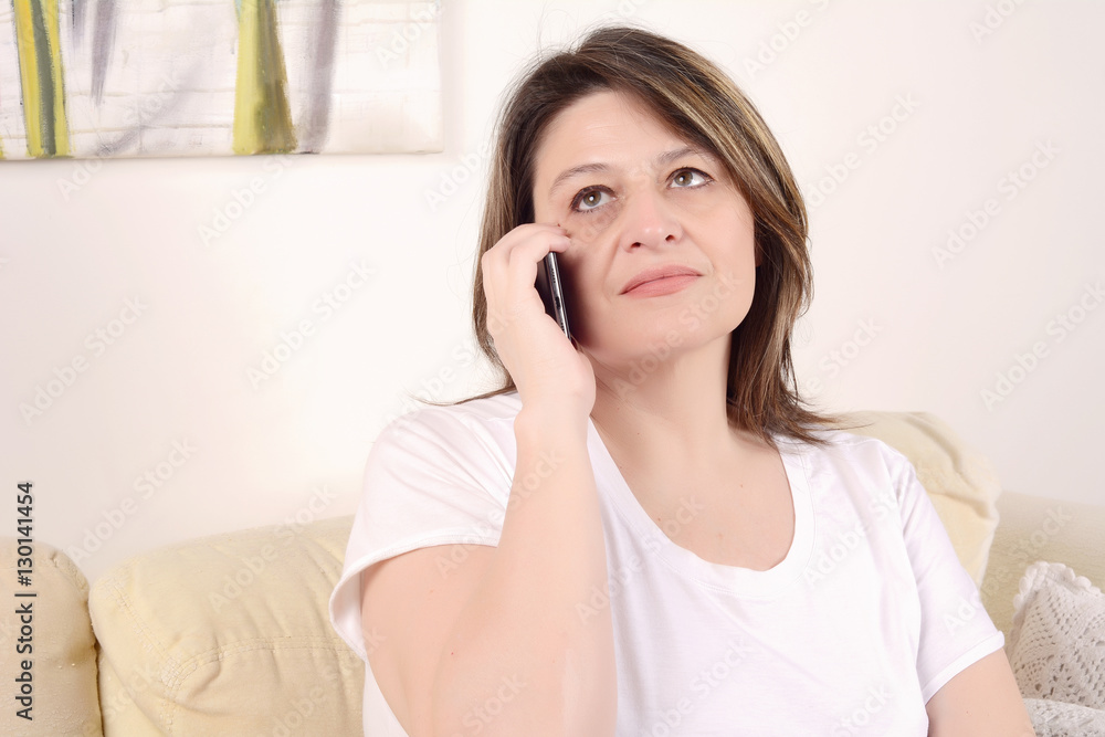 Woman talking on phone sitting on the sofa. Woman talking on phone sitting on the sofa.