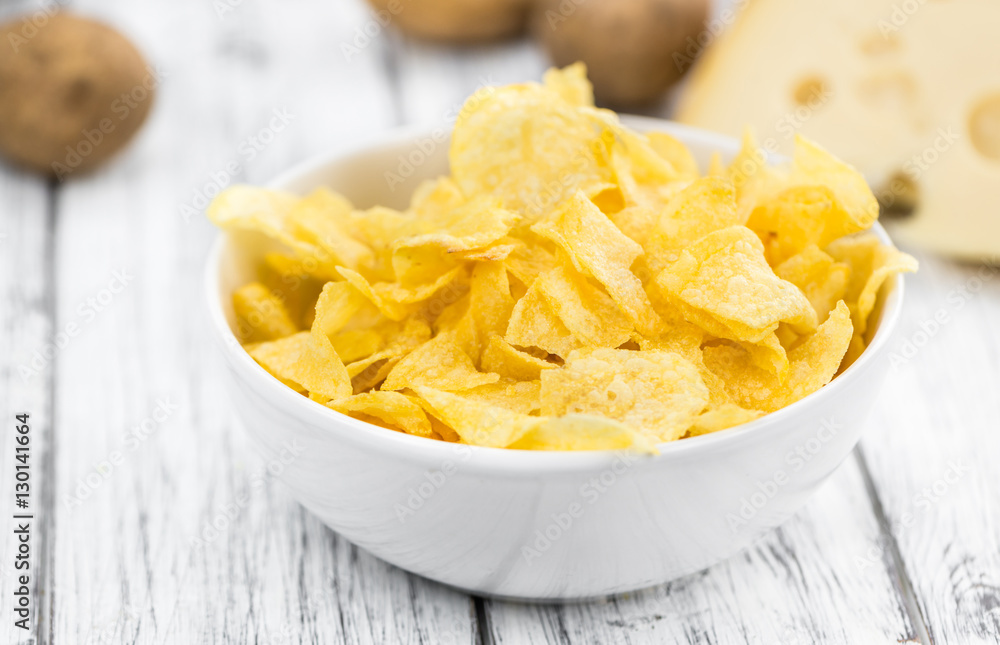 Portion of Potato Chips (Cheese and Onoion taste) on wooden back Portion of Potato Chips (Cheese and Onoion taste) on wooden back