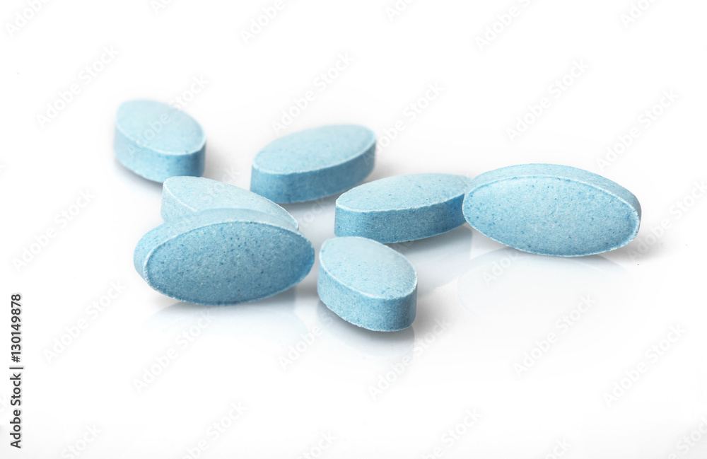 Small blue tablets spilling out of prescription container Small blue tablets spilling out of prescription container