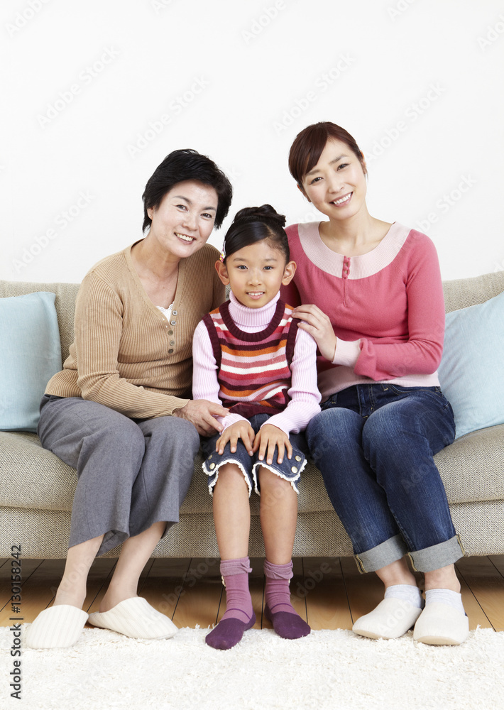 Three-generation family sitting on sofa