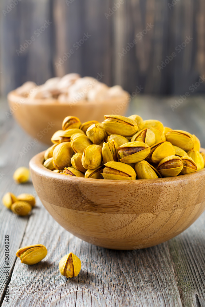 Salted pistachios with saffron in a bamboo plate. Selective focus. Salted pistachios with saffron in a bamboo plate. Selective focus.