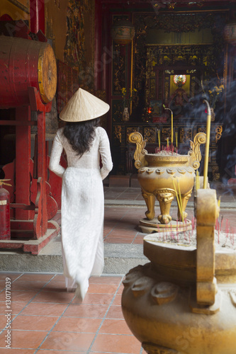 Woman wearing ao dai dress at Ha Chuong Hoi Quan Pagoda, Cholon, Ho Chi Minh City, Vietnam photo