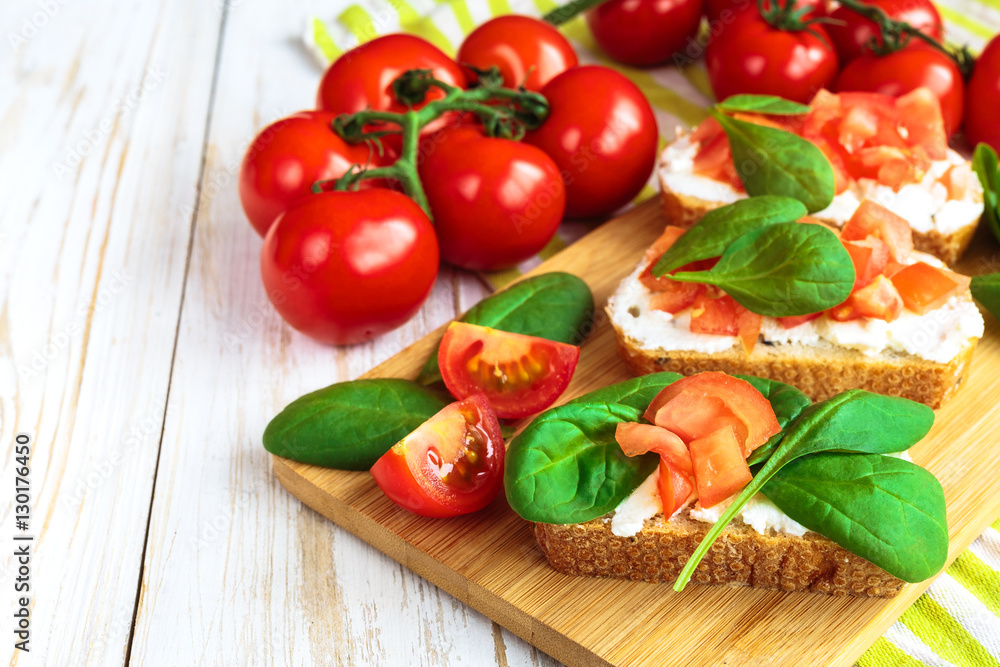 Bruschetta with spinach and cherry tomatoes on toasted baguette Bruschetta with spinach and cherry tomatoes on toasted baguette