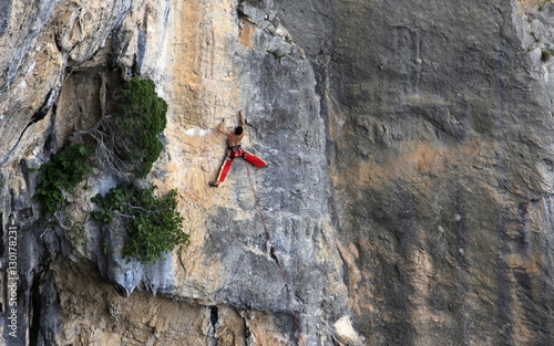 A man on a long and technically demanding face climb on the limestone cliffs of the Mascun Canyon, Rodellar, Sierra de Guara, Aragon, southern Pyrenees, Spain photo