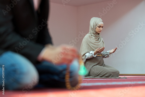 Muslim man and woman praying in mosque