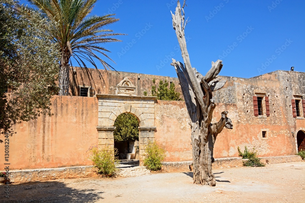 View of the bullet tree with the entrance to the refectory courtyard to the rear at Arkadi Monastery, Crete.