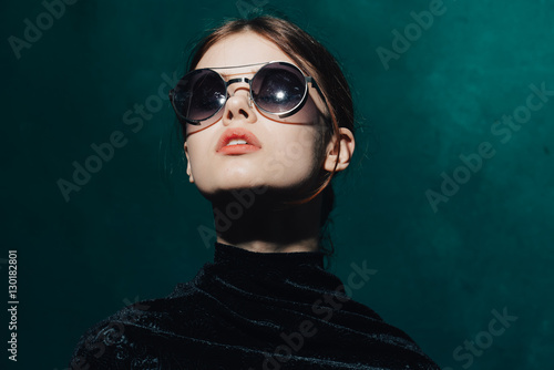 Portrait of a girl in glasses on a light background 