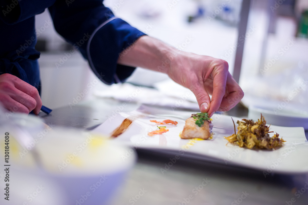 Chef preparing a cod filet with artichokes Chef preparing a cod filet with artichokes
