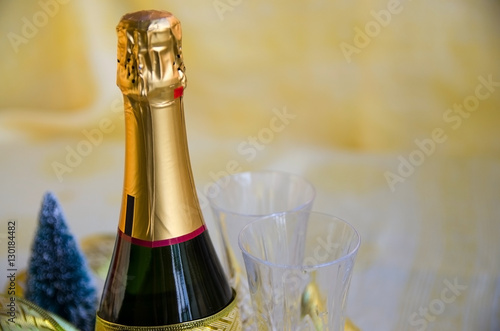 Close up of champagne with two flutes on golden background. 2017 Happy New Year concept.Copy space.