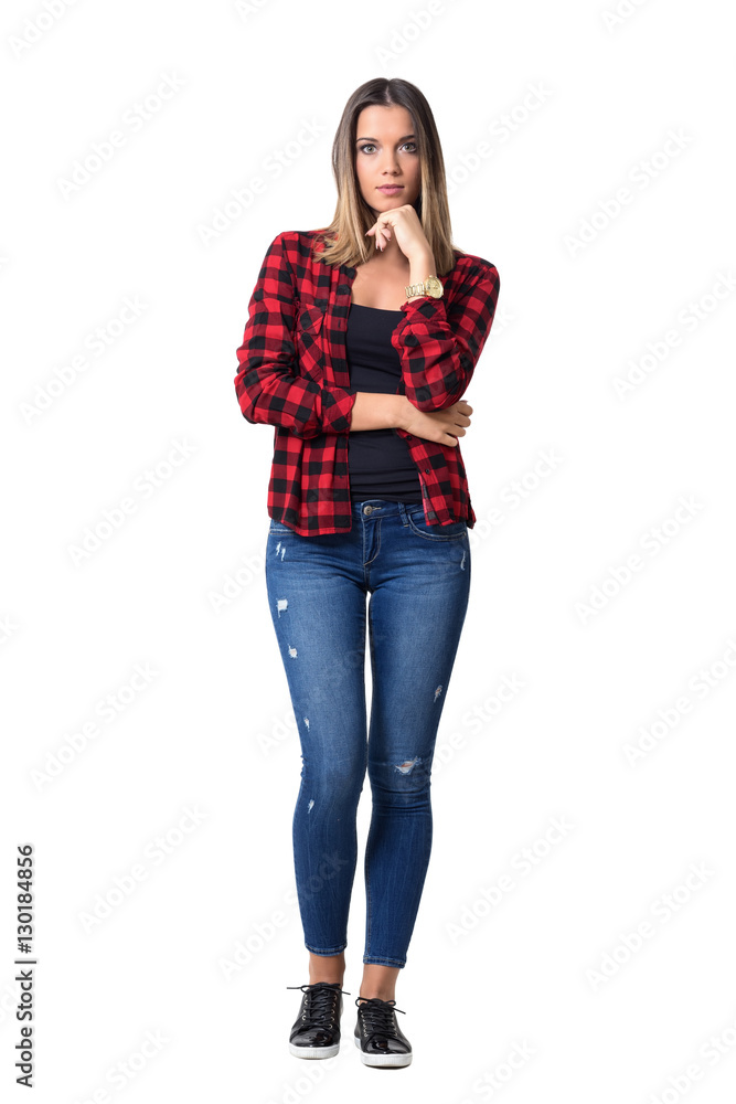 Gorgeous pensive casual woman in red checkered shirt with hands on chin looking at camera. Full body length standing portrait isolated over white background. Gorgeous pensive casual woman in red checkered shirt with hands on chin looking at camera. Full body length standing portrait isolated over white background.