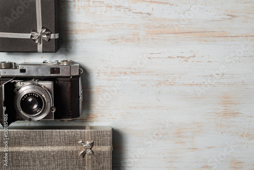 Vintage photo camera on wooden background with gift boxes. top view. copy space