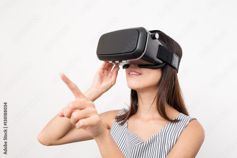 Woman using finger to touch on imaginary panel viewing on VR dev Woman using finger to touch on imaginary panel viewing on VR dev
