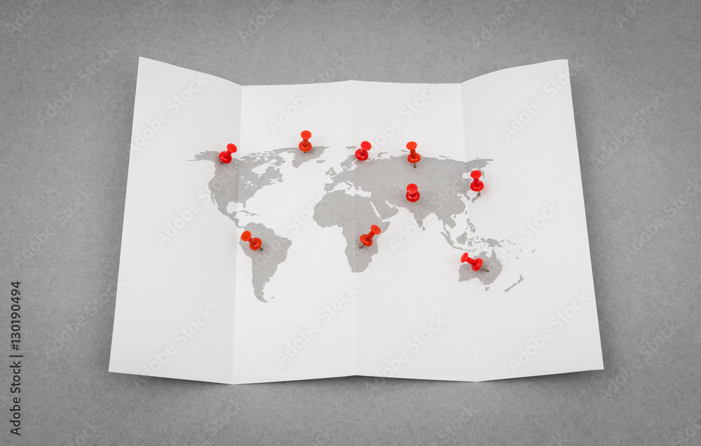 Paper folded world map  with red Pin Pointer .