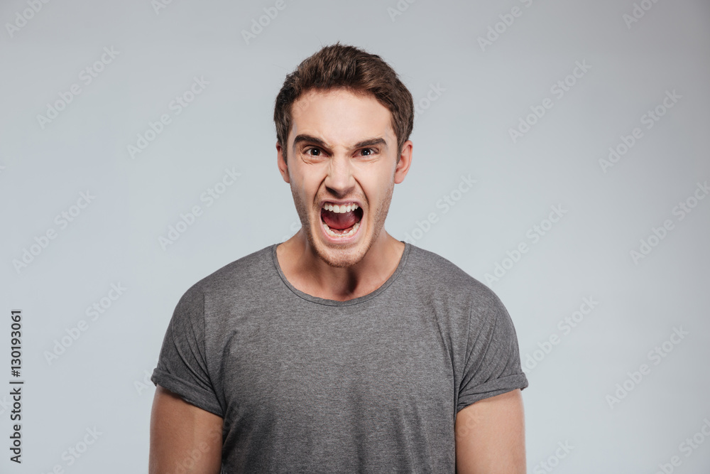 Portrait of a angry man screaming and looking at camera Portrait of a angry man screaming and looking at camera