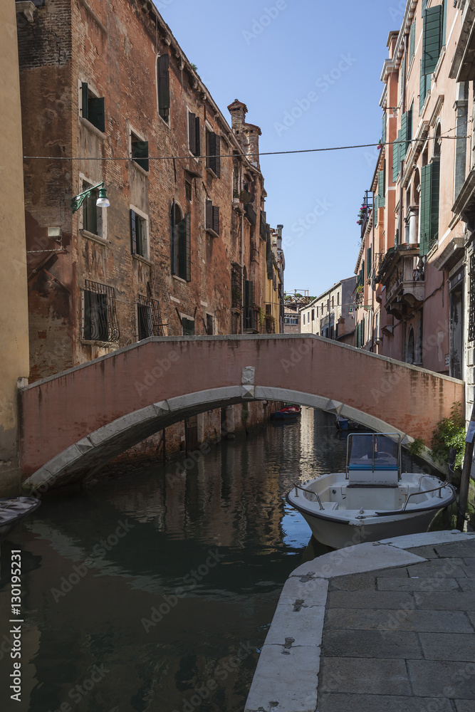 Shabby Venice. Bridge across the canal against eroded facades