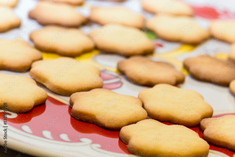 Biscotti artigianali a forma di fiore su piatto natalizio Biscotti artigianali a forma di fiore su piatto natalizio