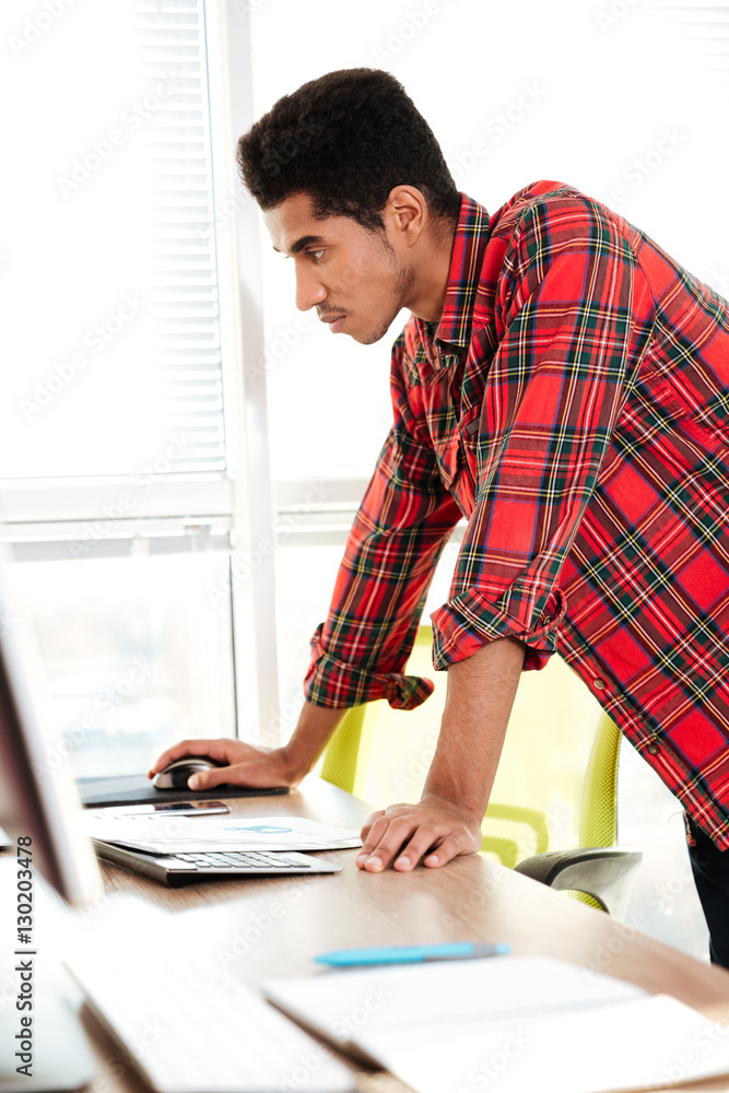 Concentrated african student looking at computer. Concentrated african student looking at computer.