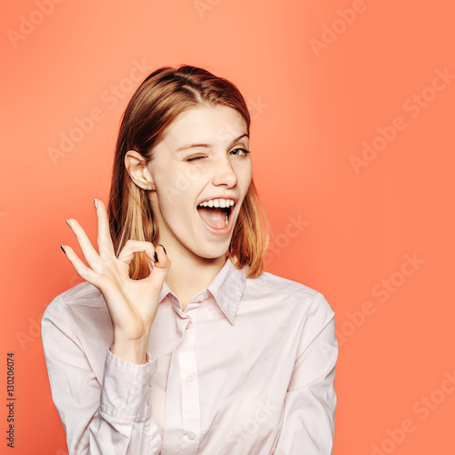 Winking girl shows ok gesture photo