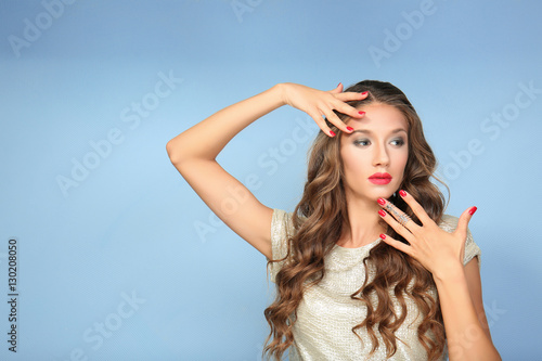 Φωτογραφία Beautiful young woman with make up and long wavy hair on color background