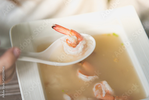 woman eating porridge rice gruel or boiled rice with shrimp