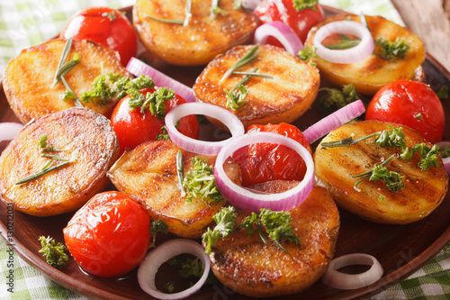 Grilled new potatoes and tomatoes with fresh red onion close-up. horizontal