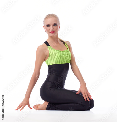Gorgeous young woman practicing yoga sitting on the floor