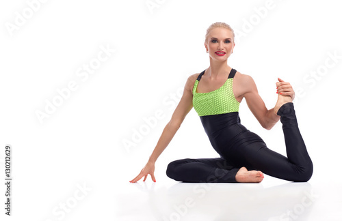 Gorgeous young woman practicing yoga sitting on the floor