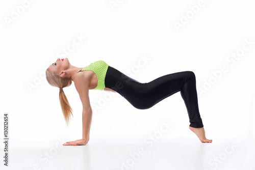 Attractive female gymnast exercising at studio