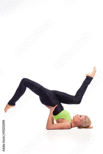 Attractive female gymnast exercising at studio