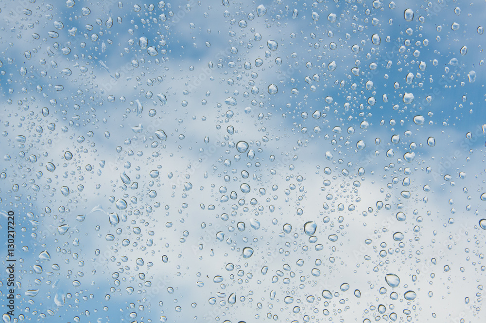 Raindrops on the window blue sky background 