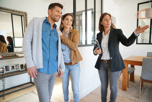 Couple with real-estate agent visiting house for sale photo