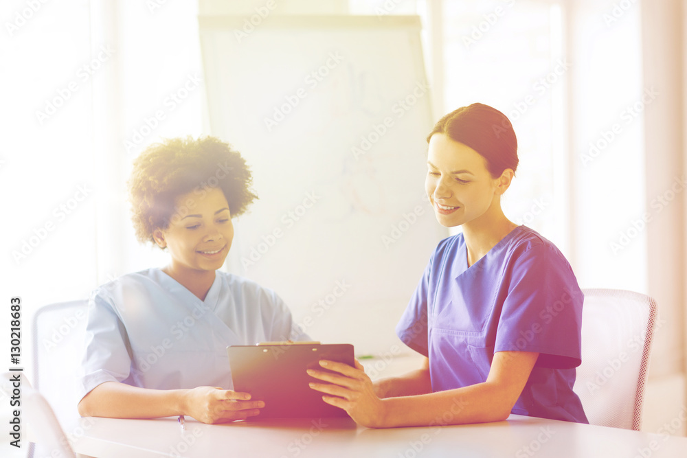 happy doctors with tablet pc meeting at hospital happy doctors with tablet pc meeting at hospital