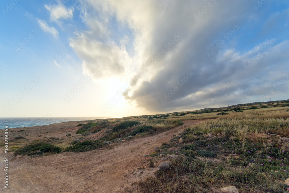 Dramatic sunset with storm cloudscape over Mediterranean Sea coastline fisheye view at sunset. Cape Greko, Cyprus.
