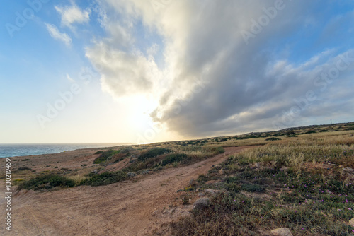 Dramatic sunset with storm cloudscape over Mediterranean Sea coastline fisheye view at sunset. Cape Greko, Cyprus.   © shujaa_777