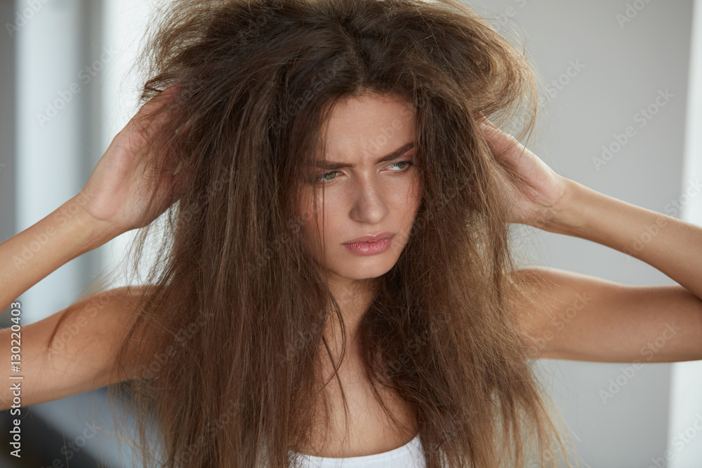 Fototapeta premium Woman With Holding Long Damaged Dry Hair. Hair Damage, Haircare.