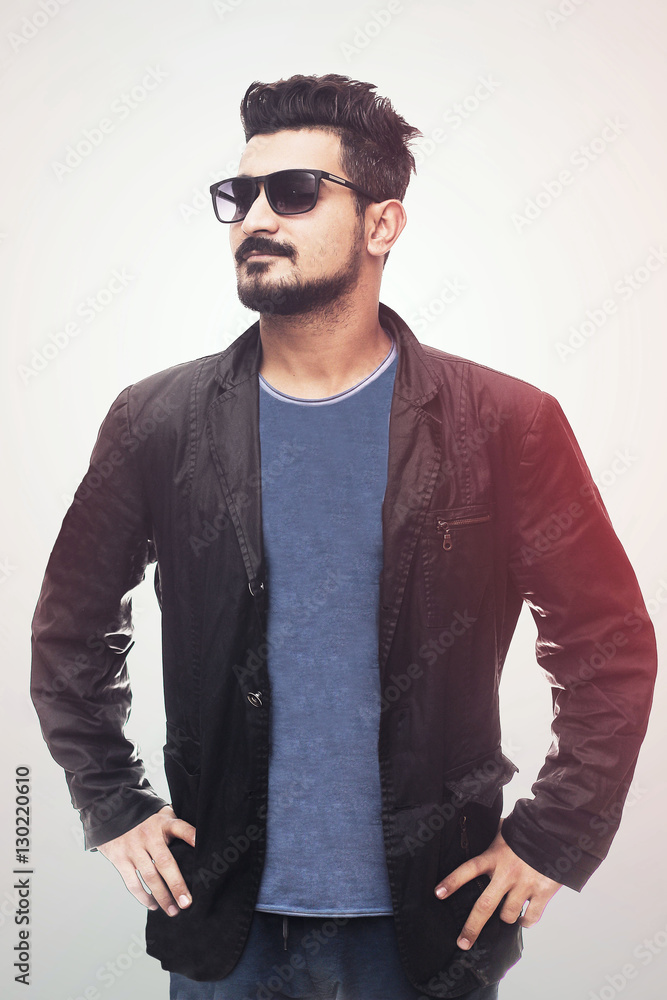 Obraz premium Handsome fashion man smiling and wearing sunglasses